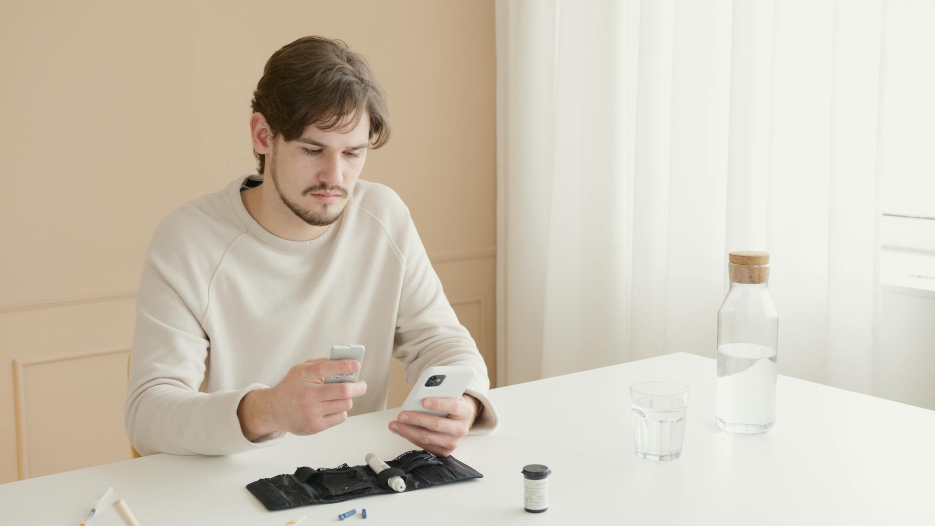 man looking at phone at table