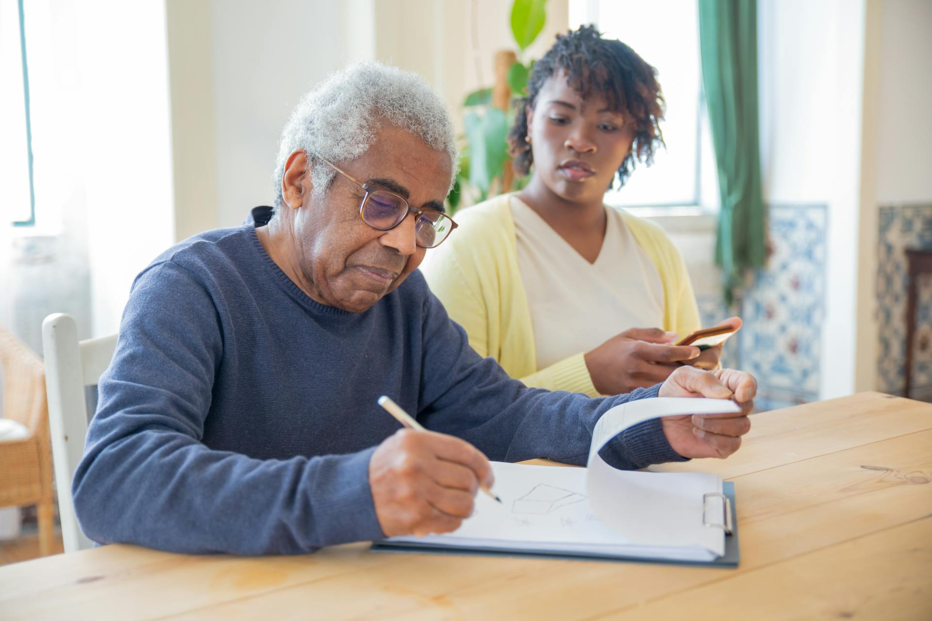 man writing with pen while woman looks